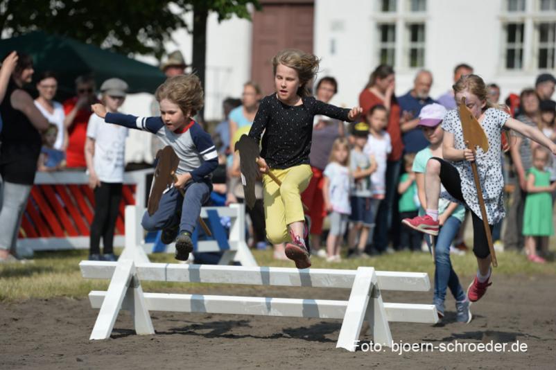 Kinder springen über ein aufgebautes Hindernis